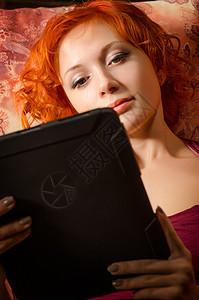 年青女人坐在沙发上 有平板电脑电子书闲暇网络电子邮件女士互联网软垫家具技术女性图片