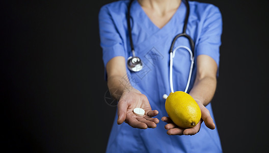 一个穿着医疗西装和听诊器的 快乐的女医生拿着柠檬急救箱女士质量活动治疗病人成人伤害女性制药图片