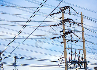 云下和蓝天空下的电线杆和电缆保险丝力量技术站立活力蓝色太阳天空基础设施金属图片