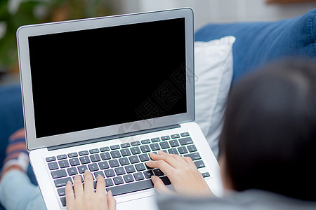 年轻的亚洲女性在家工作 使用笔记本电脑空白屏幕模型 自由职业女孩使用空笔记本 女孩打字键盘 并通过多媒体 商业和通信概念放松博主图片