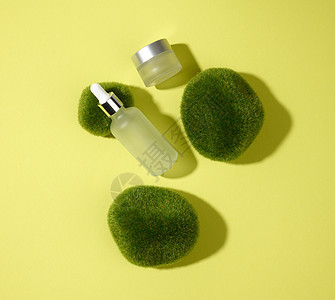 玻璃化妆品白色瓶 带有吸管 背景为绿黄色 上面有苔藓 化妆品 SPA 品牌模型 顶视图图片