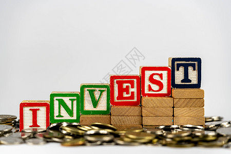 与木块和硬币的投资概念 在木块上投资字母 周围环绕着钱商业教育生长经济基金成功现金贷款木头图表图片