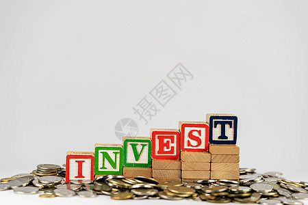 与木块和硬币的投资概念 在木块上投资字母 周围环绕着钱现金货币木头立方体退休教育成功生长商业利润图片