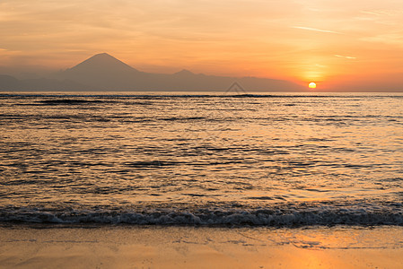 日落时在巴厘岛浏览冲浪太阳海滩蓝色地平线橙子反射热带阳光天堂图片