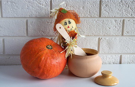 一个有木勺的稻草人 一个粘土锅和一个白色背景的南瓜 哈洛文和感恩节概念乐趣浆果节日感恩蔬菜农场符号橙子艺术家庭图片