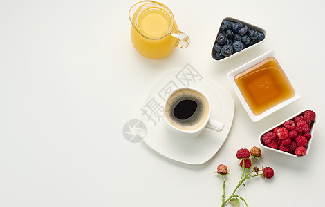 新鲜的果汁在玻璃透明的脱盐机里 一杯咖啡 蜂蜜和燕麦片放在白桌上 早饭 顶层风景图片