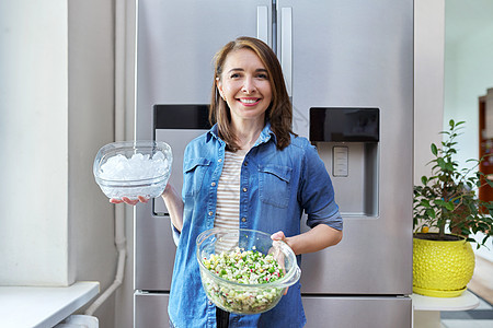 笑女人手里拿着一碗冰和蔬菜沙拉盘子食物女性营养房子饥饿冰箱厨房饮食冷藏小吃图片
