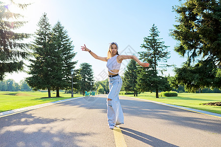 在阳光明媚的夏日在公园路上跳舞的年轻少女身体潮人公园女士舞蹈青少年行动女孩运动女性图片