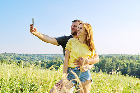 美美快乐的成年夫妇在智能手机上自拍电话假期浪漫摄影阳光相机中年男人女性女士图片