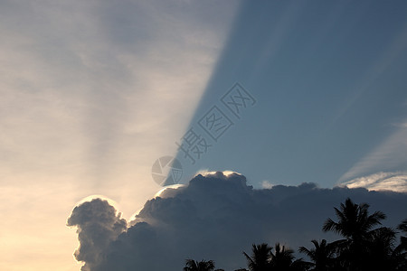 白云像人头一样形成 光线照亮天空 闪耀在天空中图片