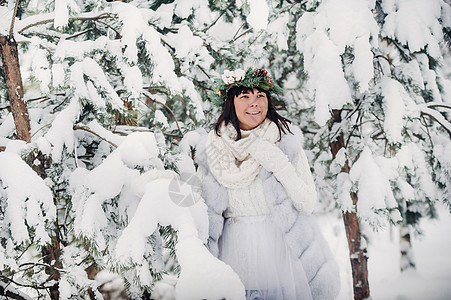 一个穿着白色衣服的女人在寒冷的冬天森林里的画像 在白雪覆盖的冬季森林里 头戴花环的女孩木头艺术雪花裙子帽子季节假期花园女士新年图片