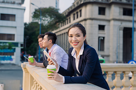 在大楼前喝咖啡的亚洲女性和男性商务人士在楼前外休息女士工作团队商务同事人士工人商业合伙员工图片