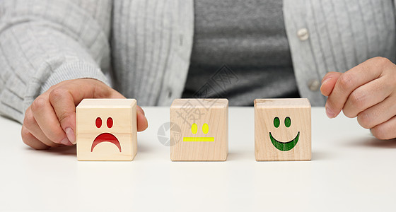 具有不同情绪的木块 从微笑到悲伤和女人的手 评估产品或服务质量 情绪状态 用户评论的概念顾客评分审查立方体商业蓝色情感客户速度排图片
