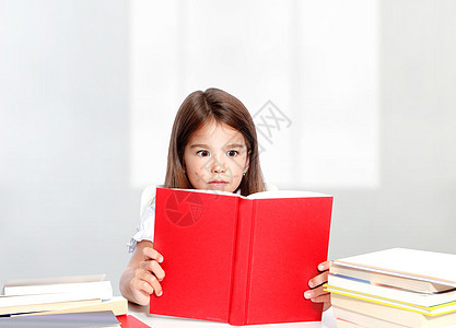坐在桌边读书的可爱的小女孩小学生学校教育知识班级幼儿园孩子家庭作业童年好奇心图片