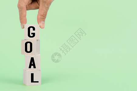 手持木制立方体 带有 GOAL 字样 以在企业中取得成功图片