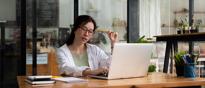 在记事本中工作或在笔记本电脑上学习的女性写作列表的裁剪照片  教育课程或培训 研讨会 在线教育概念成人职场商务人士女士女孩办公室图片