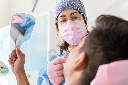 牙科诊所在镜中看牙的病人治疗男人成人卫生职业检查健康办公室两个人女性图片
