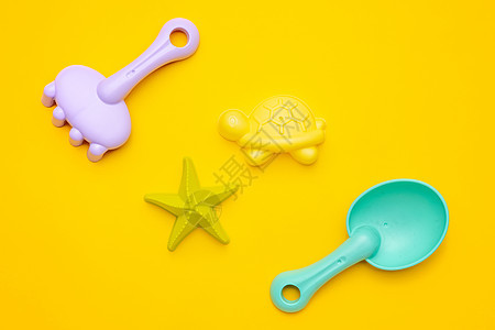 黄色背景上的塑料沙滩玩具柔和的颜色 精细运动概念的发展 创意游戏和夏季概念模具闲暇孩子们娱乐沙坑海滩团体活动婴儿红色图片