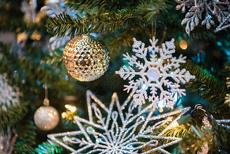带有金灯泡和闪光雪花的圣诞树装饰品 特写你图片
