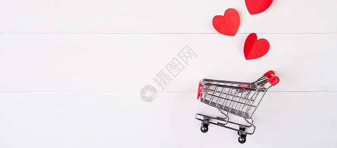 木桌上的购物车和心形纸 2 月 14 日节日情人节的销售概念 超市和商店 符号和庆祝活动 商业和假日销售概念大车假期礼物桌子广告图片