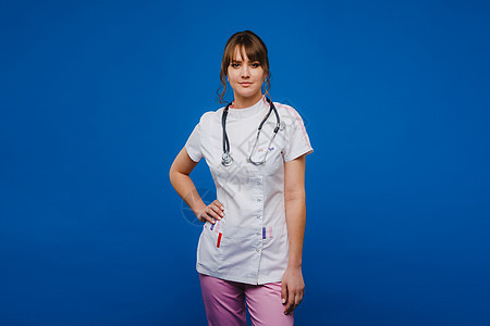 一位女医生在医院的医生办公室里打着手势 用蓝色背景中突显的听诊器检查心跳从业者专家病人疾病诊所健康女孩卫生工作护士图片