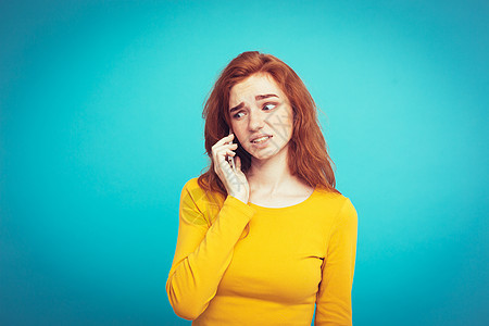 生活方式概念     以手机与朋友交谈时令人震惊和紧张地表达的姜红头发女孩肖像 在蓝面纸背景上孤立无援 Copy space细胞图片