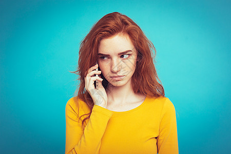 生活方式概念     以手机与朋友交谈时令人震惊和紧张地表达的姜红头发女孩肖像 在蓝面纸背景上孤立无援 Copy space细胞图片