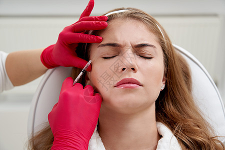 向年轻女性的脸部注射美容剂 使用生物再生法对模仿皱纹进行滑动注射器皮肤科胶原女孩护理程序医生成人女士皮肤图片