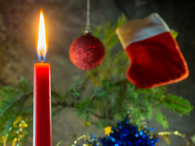 圣诞红蜡烛在Fir树枝的背景下烧伤图片