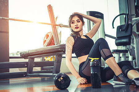 亚洲年轻女性在健身房和运动俱乐部中心放松身心 配备设备和哑铃 锻炼和力量训练概念 美丽和健康的主题 体育馆背景活动运动员微笑鞋类图片