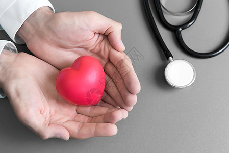 医生手牵着手给病人做红色按摩心脏 让病人康复 医院和医疗保健概念 心脏病发作和疾病的心肺复苏术和心脏病学 心脏捐赠和康复图片