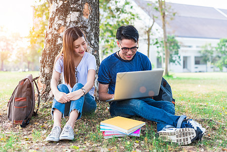 两个亚洲青年大学生讨论用笔记本电脑测试的家庭作业和期末考试 教育和友谊的概念 幸福和学习的概念 恋人和朋友的主题图片