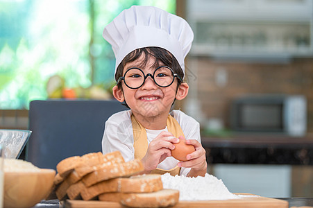 画像可爱的亚洲快乐小男孩对在家里的厨房里做饭很感兴趣 人们的生活方式和家庭 自制食品和配料的概念 烘烤圣诞蛋糕和饼干 微笑的孩子图片