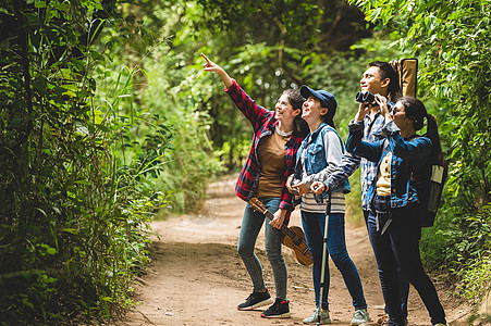 一群亚洲朋友一起冒险在森林里远足和露营 家庭旅行放松 野生动物概念中的徒步旅行和小径活动 指着树或天空的女人 复制空间木头女性远图片