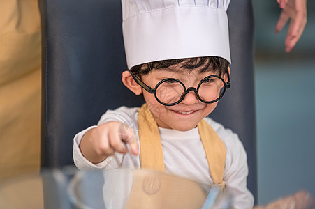 肖像可爱的亚洲快乐小男孩有兴趣在家里的厨房里和妈妈一起做饭 人们的生活方式和家庭 自制食品和配料的概念 烘烤圣诞蛋糕和饼干童年男图片