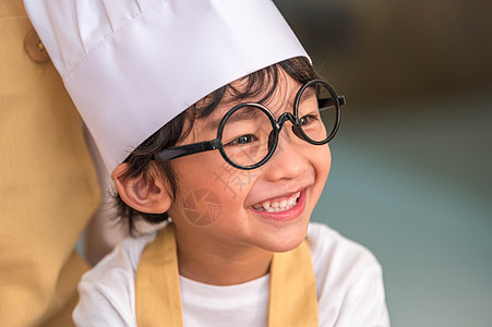 肖像可爱的亚洲快乐小男孩有兴趣在家里的厨房里和妈妈一起做饭 人们的生活方式和家庭 自制食品和配料的概念 烘烤圣诞蛋糕和饼干工作菜图片