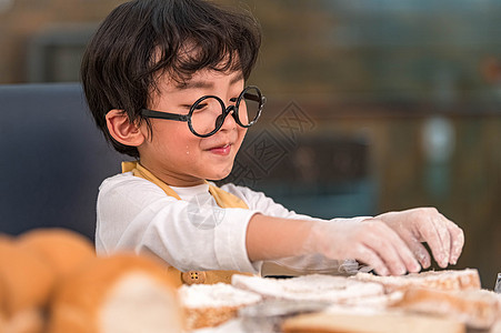 画像可爱的亚洲快乐小男孩对在家庭厨房里搞笑的烘焙面包店感兴趣 人们的生活方式和家庭 自制食品和配料的概念 烘烤圣诞蛋糕和饼干食谱图片