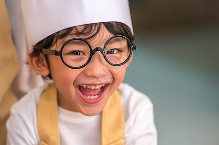 肖像可爱的亚洲快乐小男孩有兴趣在家里的厨房里和妈妈一起做饭 人们的生活方式和家庭 自制食品和配料的概念 烘烤圣诞蛋糕和饼干微笑商图片