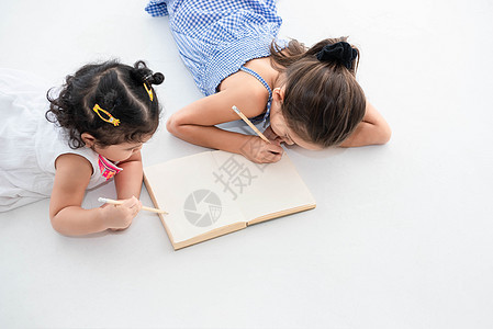 在家里或托儿所一起在素描本上画快乐的两个姐妹的顶视图 人们的生活方式和孩子们玩耍 教育和儿童概念 不同的种族和年龄 回到学校主题图片