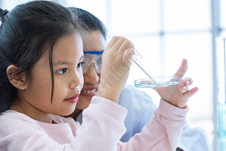 科学家女孩和老师一起用吸管将溶液物质液体滴入实验室教室的试管中 教育和科学 微米和纳米技术 电子保健和医疗概念管子职业成人测试乐图片