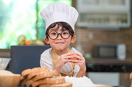 画像可爱的亚洲快乐小男孩对在家里的厨房里做饭很感兴趣 人们的生活方式和家庭 自制食品和配料的概念 烘烤圣诞蛋糕和饼干 微笑的孩子图片