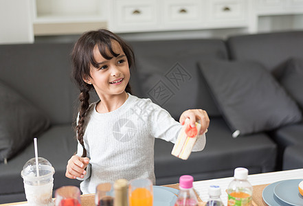 快乐的小女孩在客厅里作为厨师给三明治烹饪玩具 嬉戏的儿童和幸福教育与发展理念 可爱女孩的学习和休闲 托儿所和日托主题图片