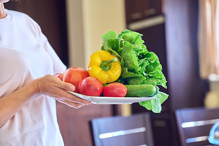 将西红柿 黄瓜 辣椒和生菜的盘子紧贴在妇女手中饮食女士厨房食物胡椒沙拉营养叶子烹饪农业图片