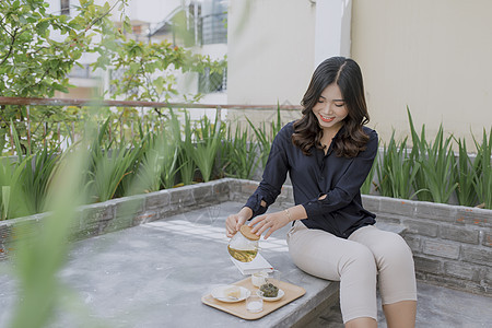 年轻的亚洲妇女享受着舒适的露台图片