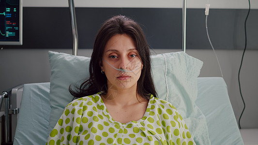 身穿鼻喉氧管躺在床上的生病妇女的肖像图片