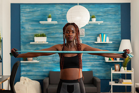 坐在客厅的黑人强健女子正在健身中虚拟机训练灵活性肌肉地面加薪身体有氧运动房子橡皮图片