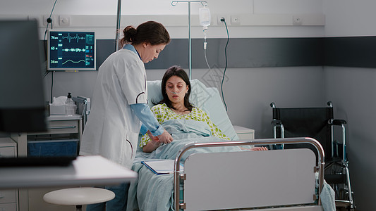 执业专家 检查住院生病妇女躺在床上的住院病人;图片