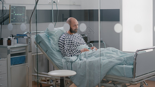 坐在床上等待呼吸道治疗的有压力的病患男子图片