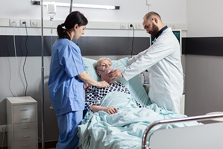 接受住院治疗的高级妇女吸入和呼气通过老年病人保险治愈护士情况护理房间说谎医院图片