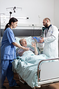 医疗队帮助在医院床上躺床的高级女病人情况护理住院疾病医师老年说谎诊所女士输液袋图片